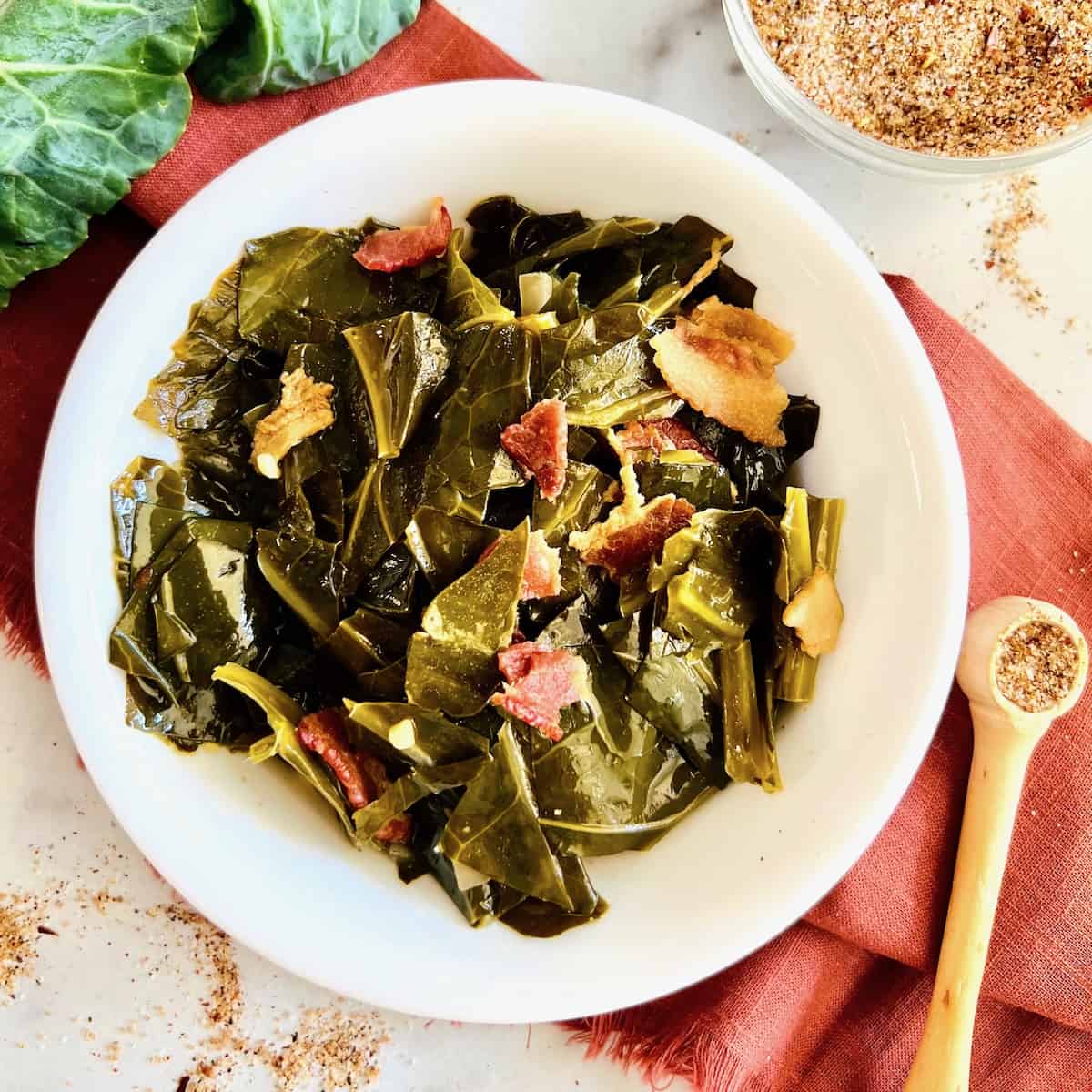A white plate filled with slow cooked collard greens.