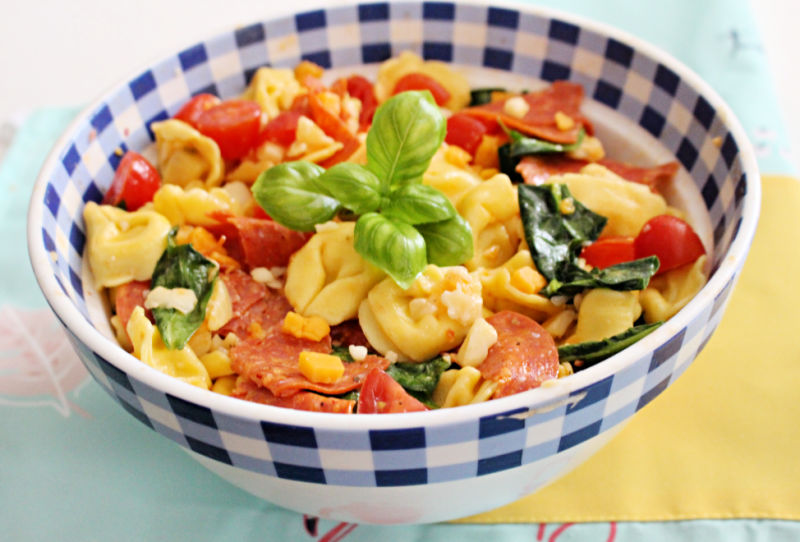 Tuscan pasta salad in a pretty blue checkered bowl.