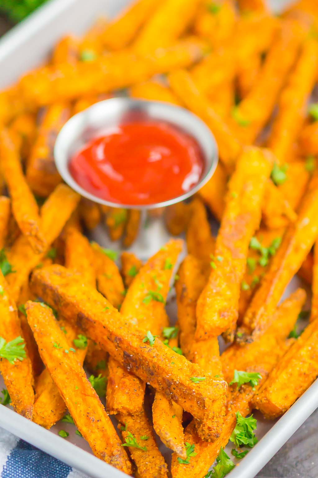 Baked sweet potato fries in a white serving tray.