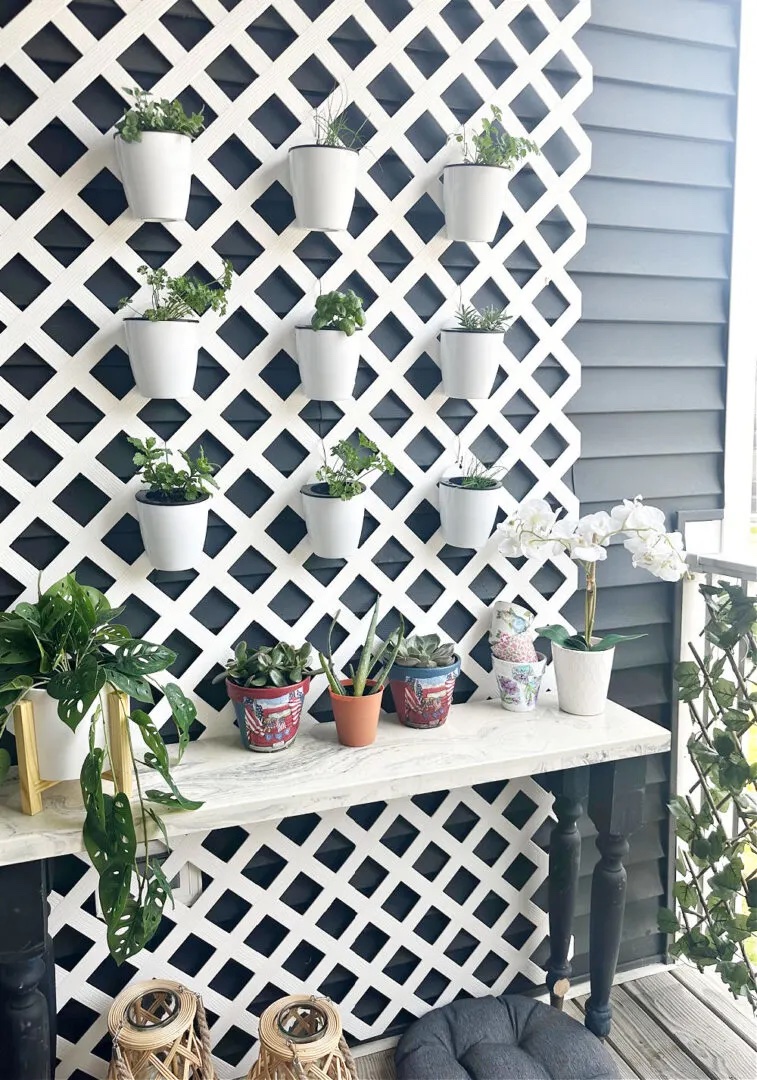 Vertical garden with pots attached to a fence.