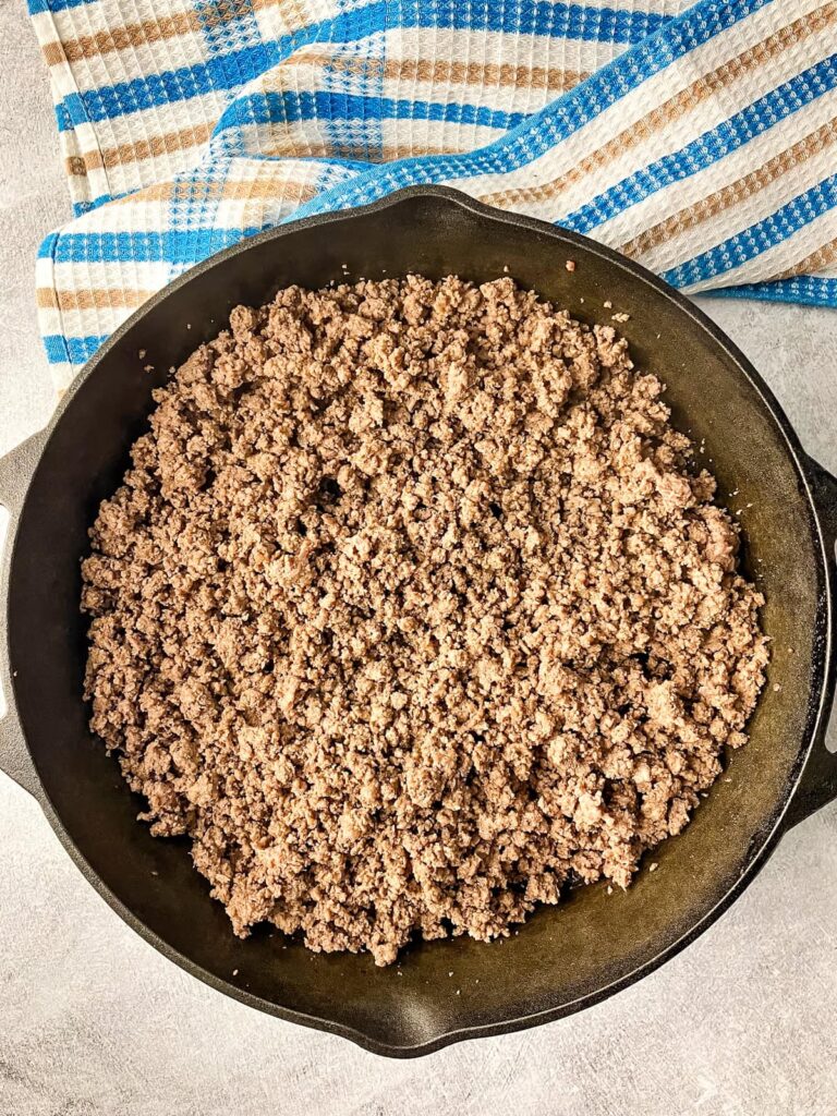 Browned ground beef in a cast iron skillet.