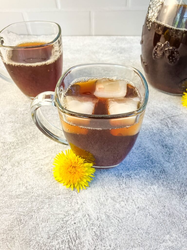 2 glasses of dandelion iced tea with ice cubes.