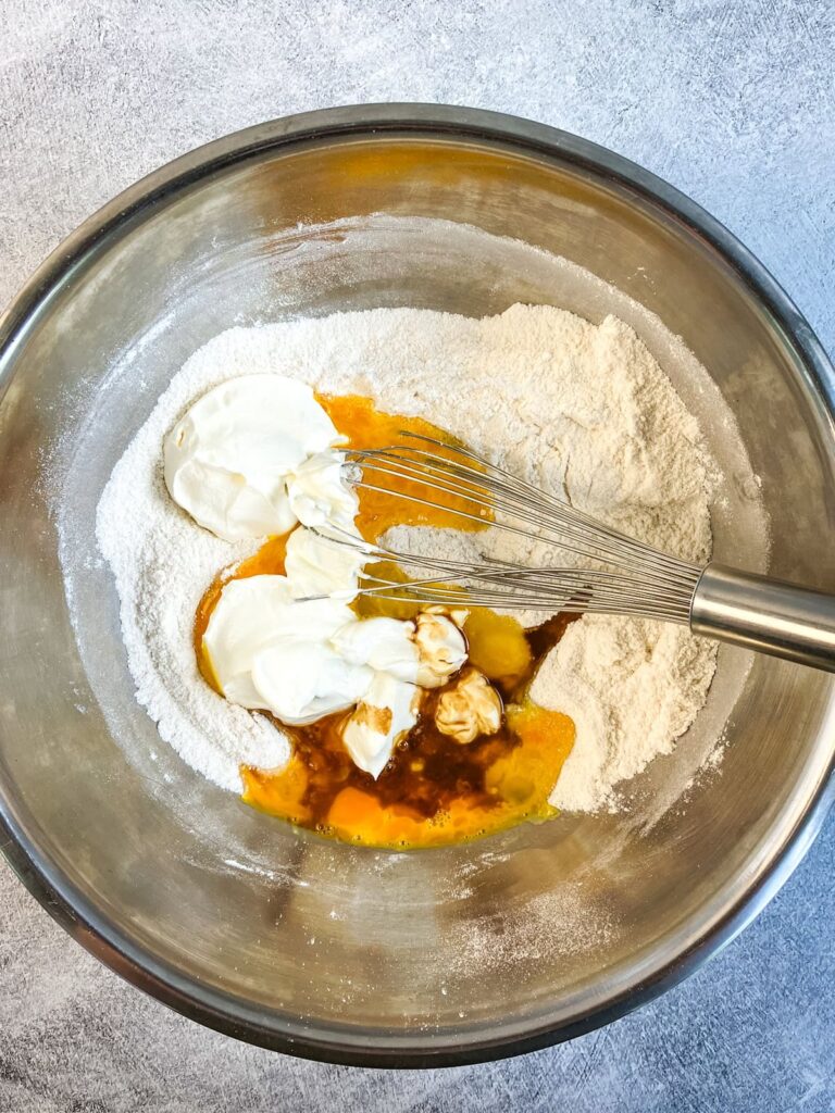 Eggs, sour cream, and vanilla added to the dry ingredients for the cake.