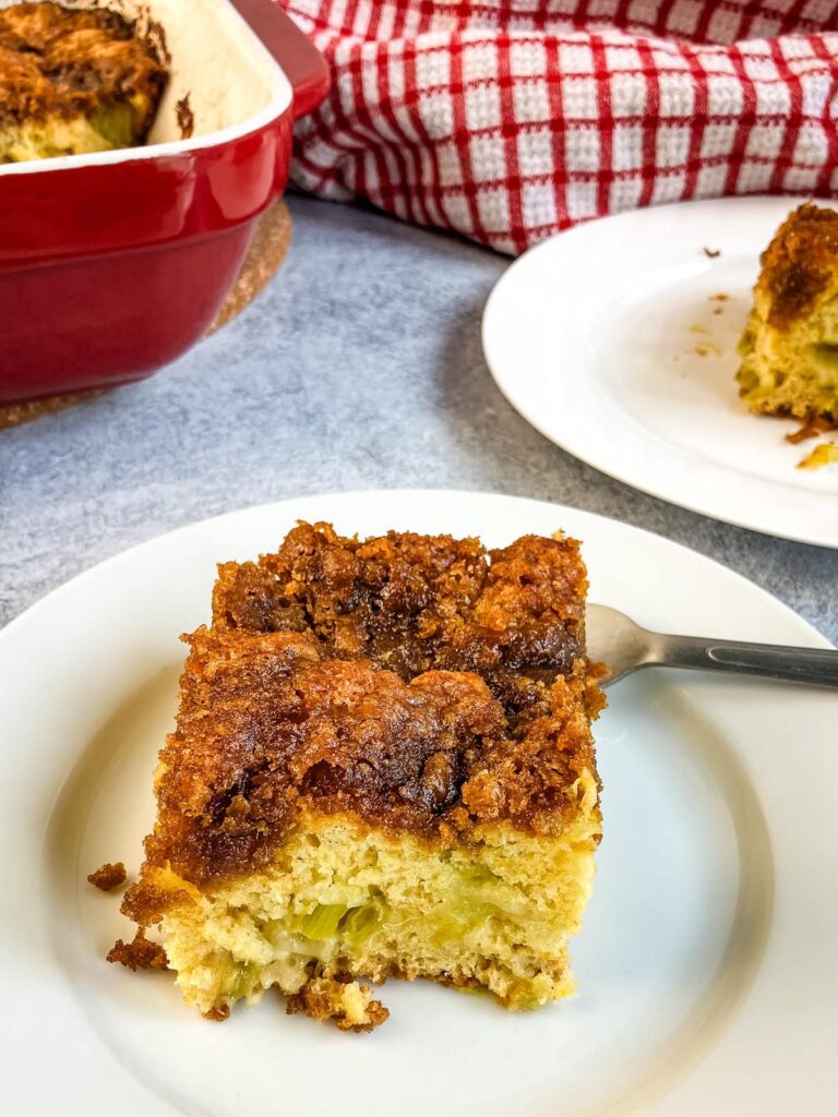 A slice of homemade rhubarb coffee cake on a white plate.
