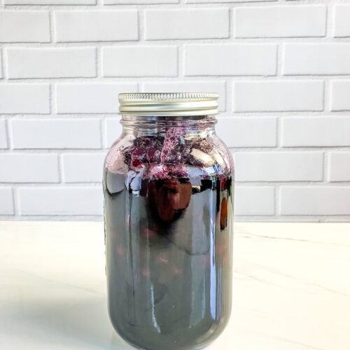 Mason jar of home canned blueberries on a counter.
