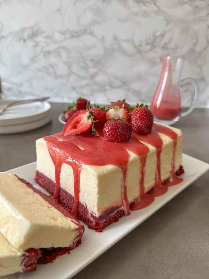 Red velvet semifreddo on a serving platter and topped with strawberry sauce.