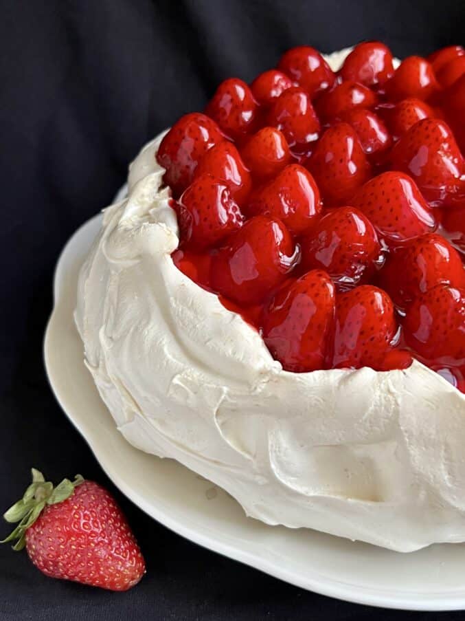 Strawberry pavlova topped with fresh berries and glaze.