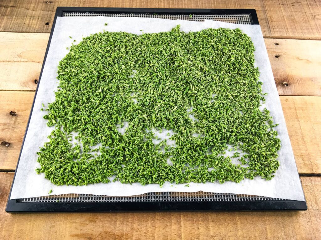 Diced garlic scapes after drying on a dehydrator tray.