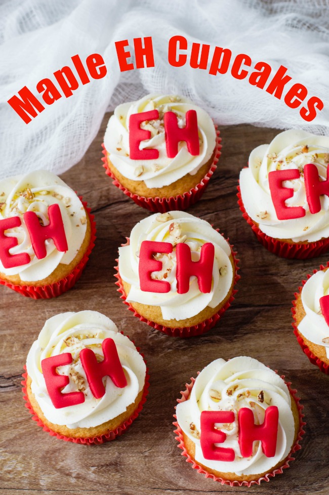White cupcakes with white frosting and the word EH on top. Text overlay says Maple Eh Cupcakes.