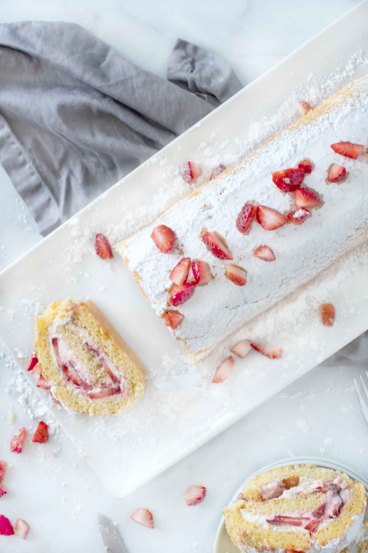 Strawberry cake roll with fresh strawberries on top.