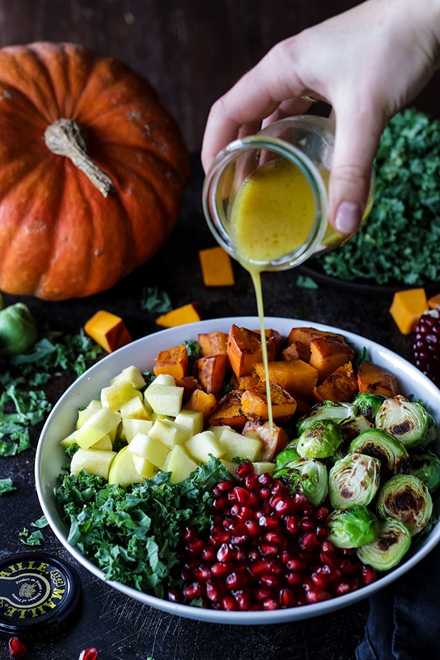 Pouring dressing over the kale and pumpkin salad.