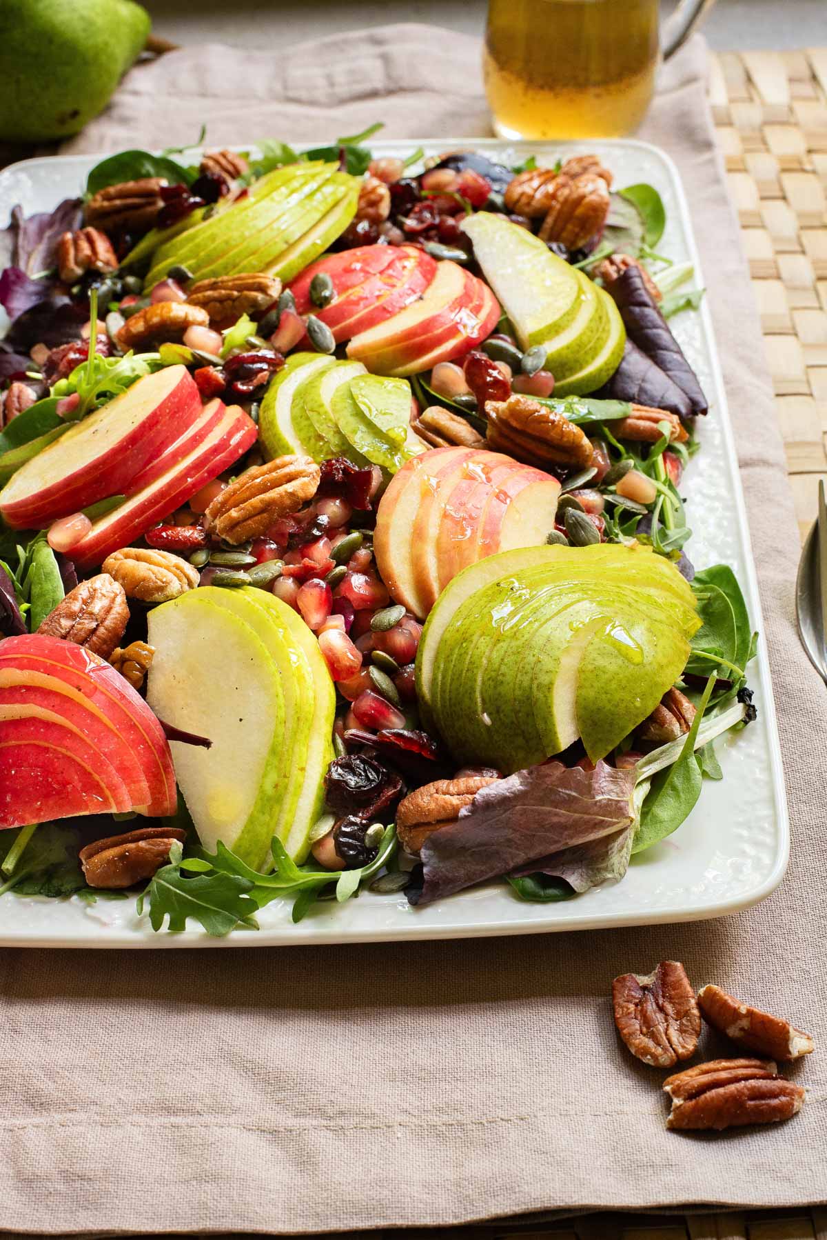 Thanksgiving salad loaded with apples, nuts, and berries on a platter.
