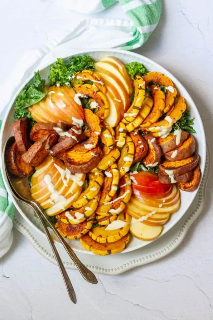 Delicata squash salad with sweet potato and apple on a large white serving tray.