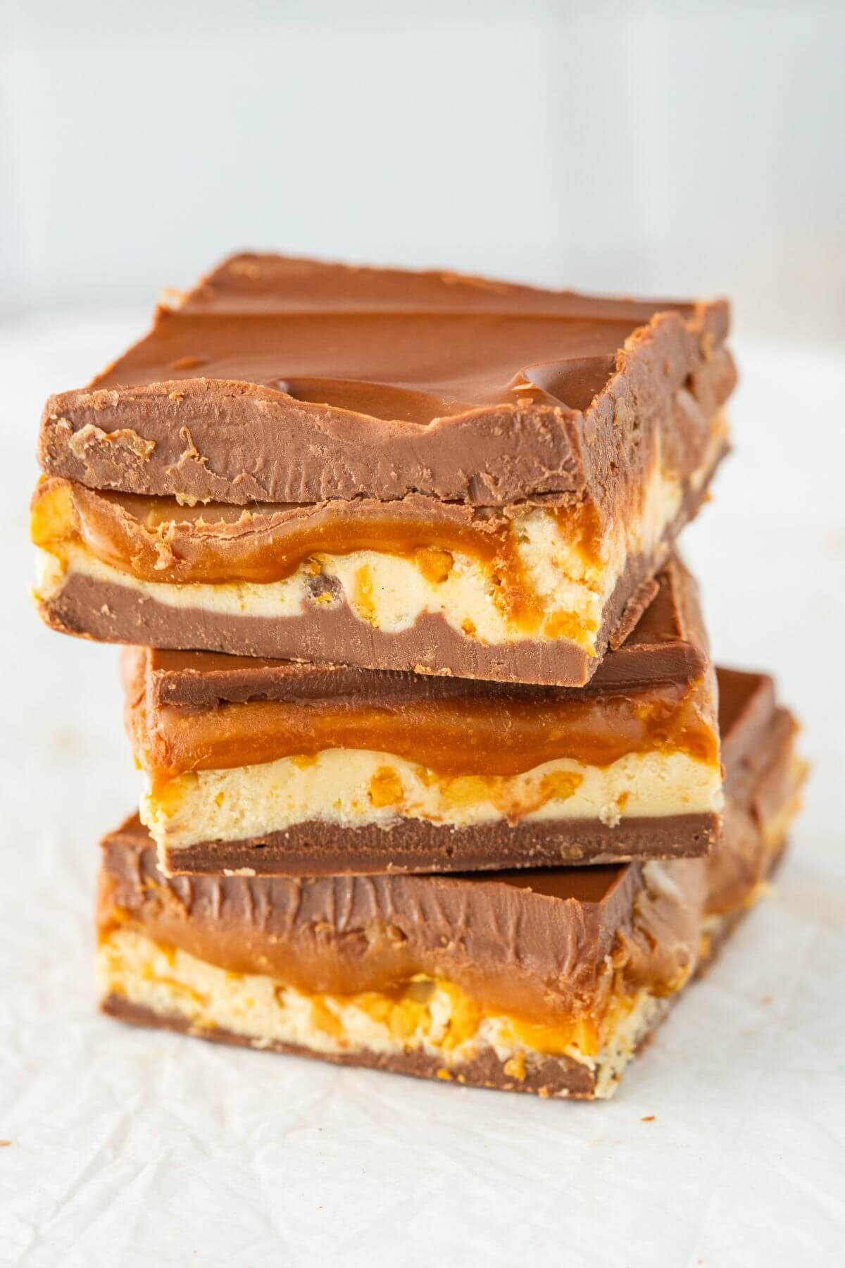 Squares of Snickers candy fudge on a plate.