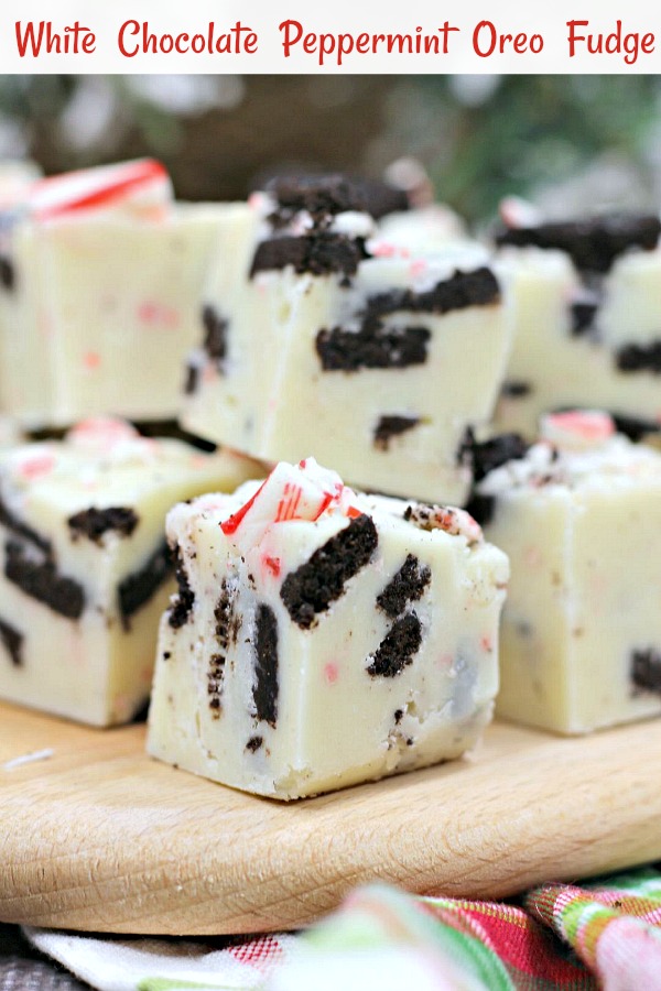 White chocolate and peppermint fudge with Oreos cut into squares on a wooden serving tray.