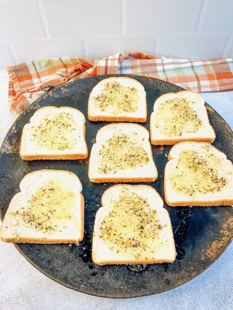Homemade garlic butter spread over the bread slices.