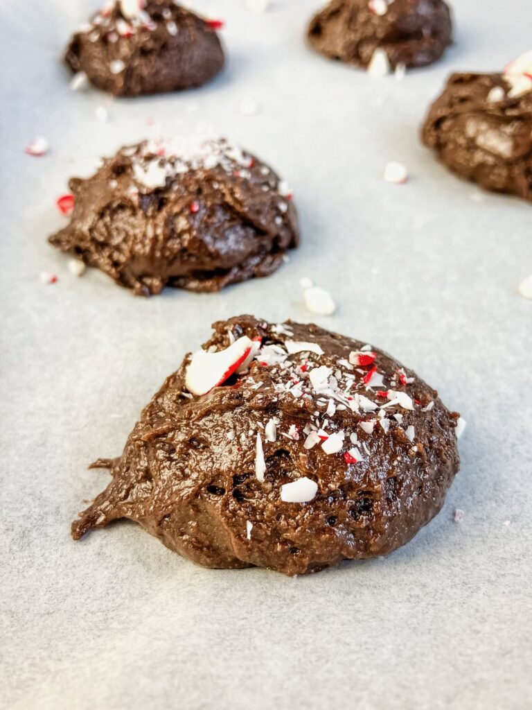 Crushed candy canes sprinkled on top of chocolate cookie dough.