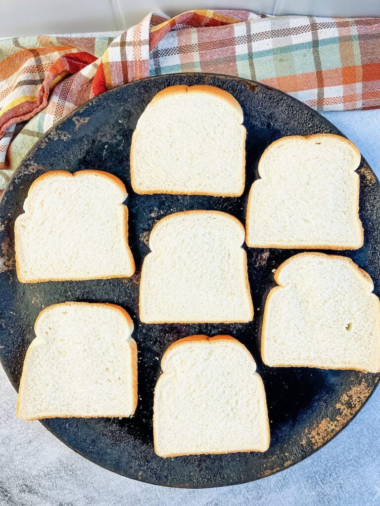 Seven slices of bread on a baking pan.