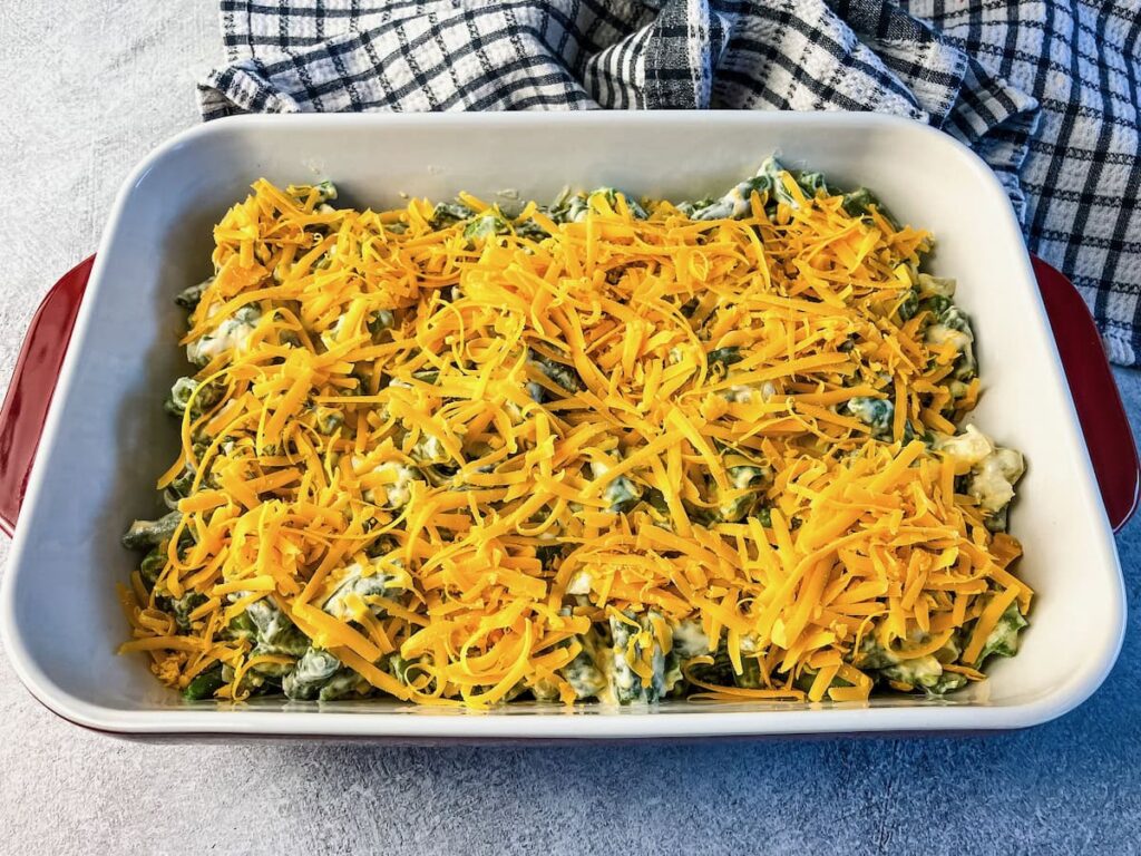 Shredded cheddar cheese on top of the green bean casserole.