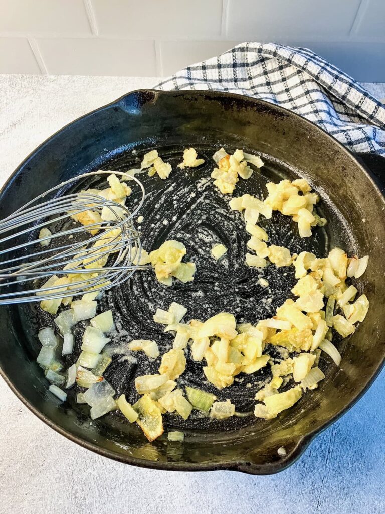 Stirring flour into onions and butter in a skillet.