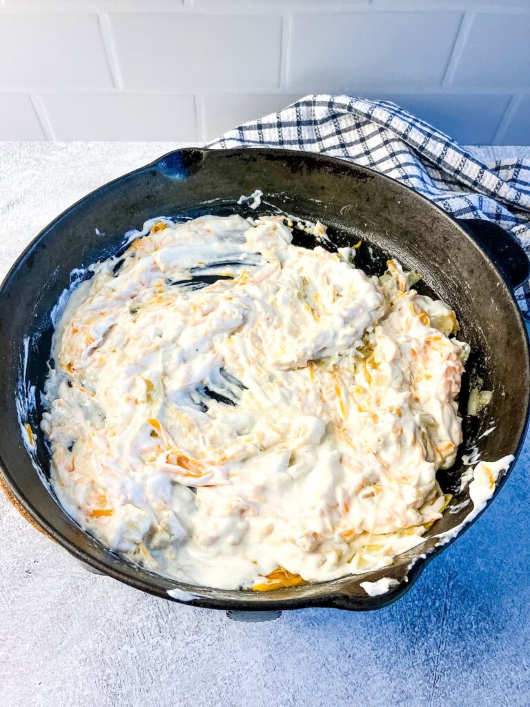 Skillet with a homemade sour cream sauce for green bean casserole.