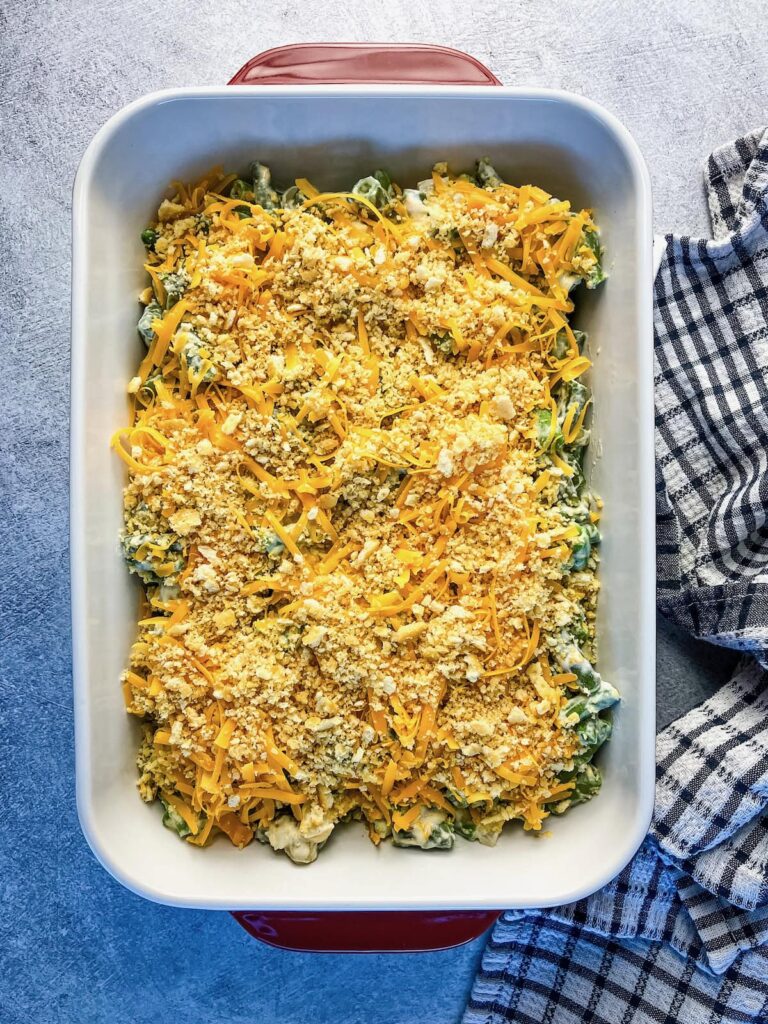 Homemade green bean casserole with buttery cracker topping ready to bake.