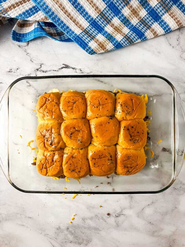 The tops of the slider rolls are basted with garlic butter.