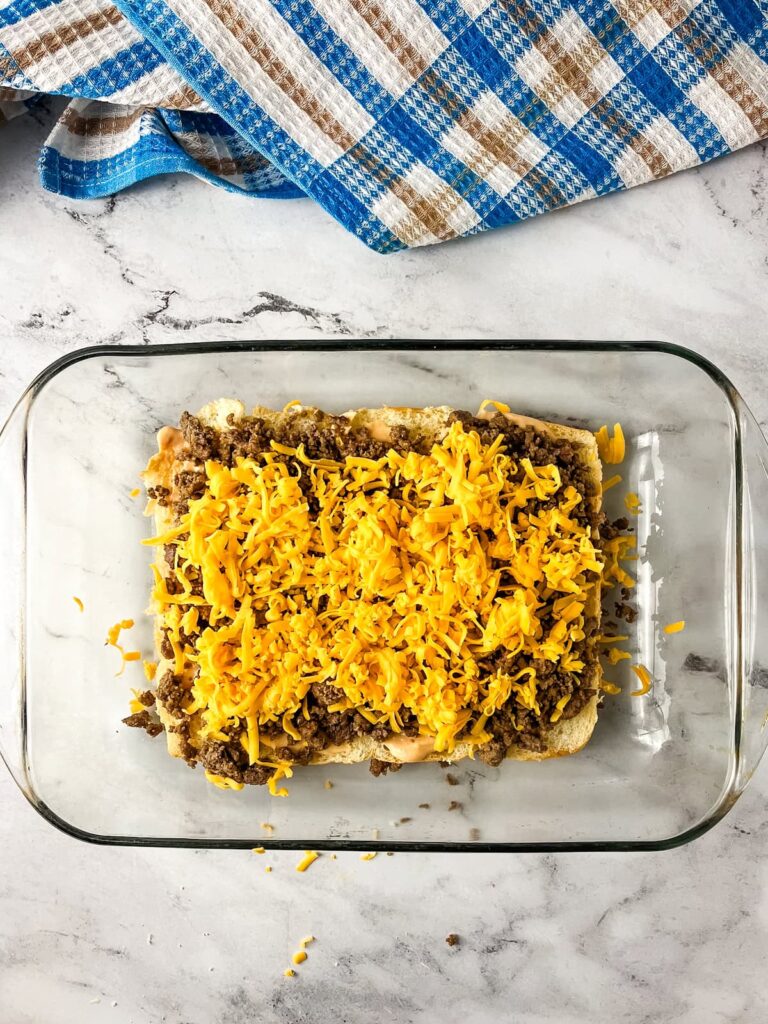 Cooked ground beef and shredded cheese added on top of the rolls.