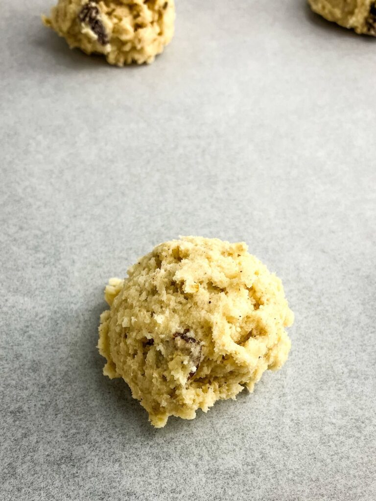 Oatmeal raisin cookie dough ball on a baking sheet.