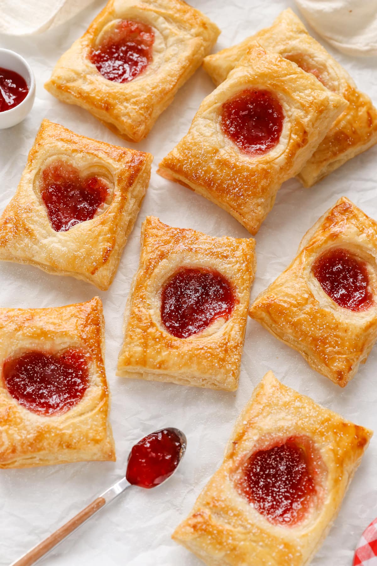 Homemade puff pastry jam tarts laying on a table.