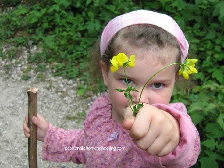 Young girl holding yellow flowers.