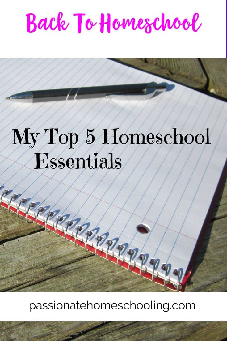 Notebook and pen laying on a table outside. Text overlay says Back To Homeschool My Top 5 Homeschool Essentials.