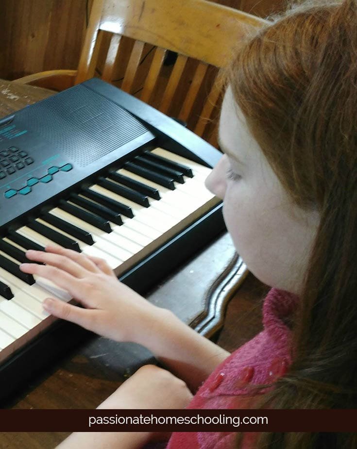 Girl practicing playing the keyboard.
