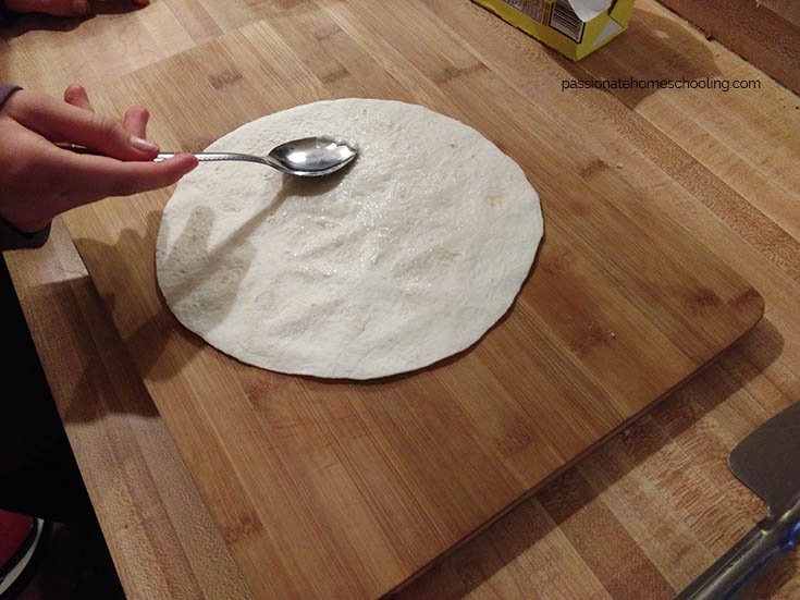 Spreading butter on tortillas.