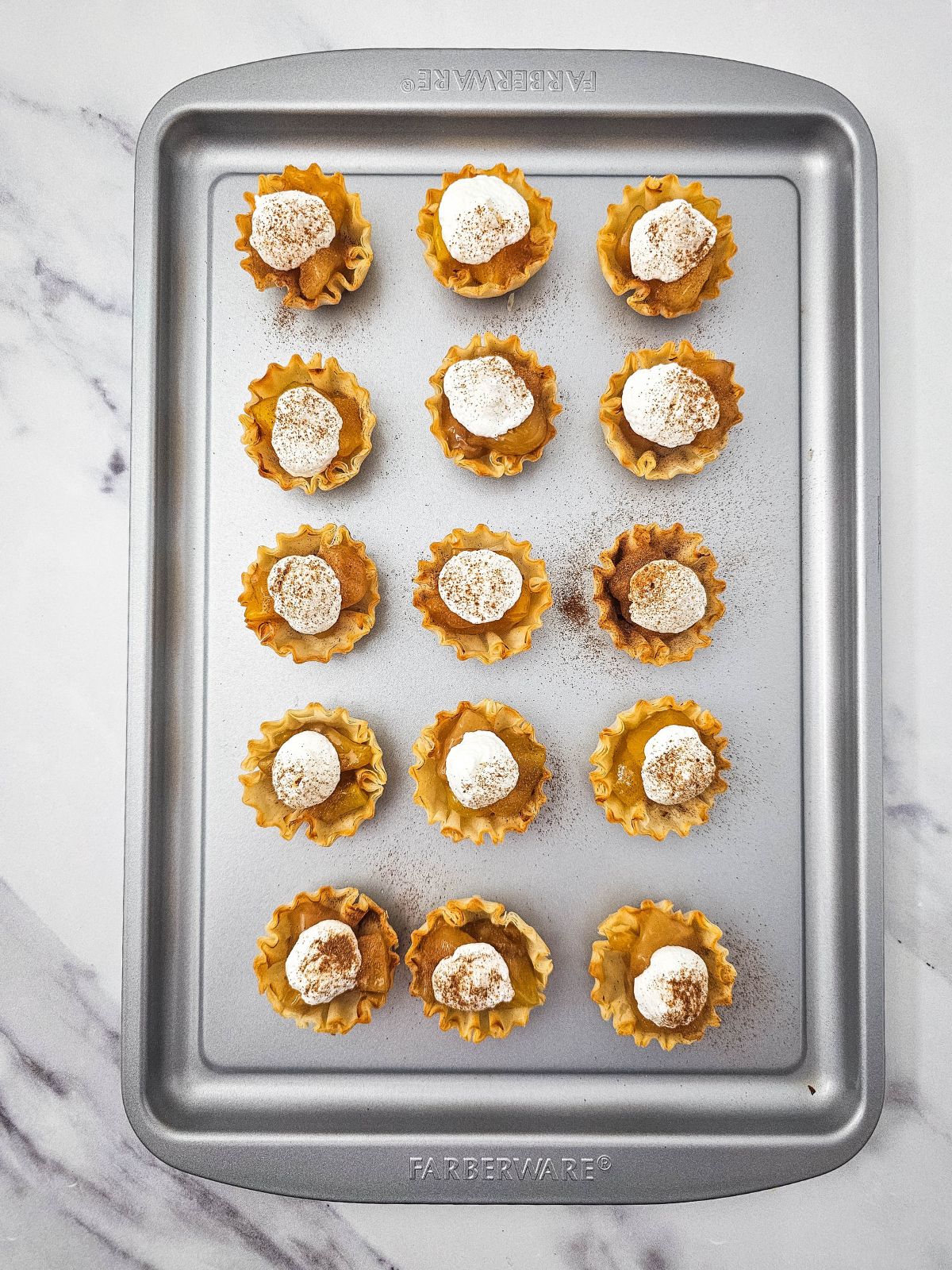 Ground cinnamon sprinkled over the top of the peach pie filling and whipped topping.