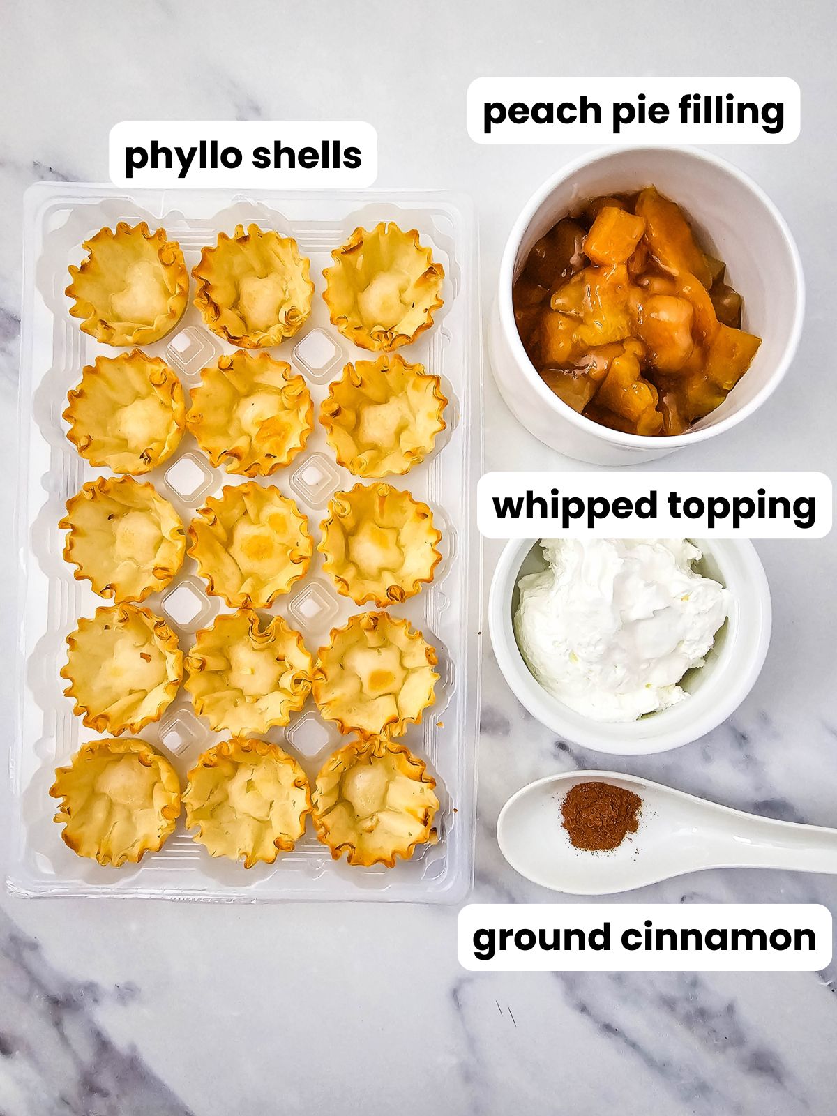 Ingredients showing phyllo shells, peach pie filling, whipped topping, and ground cinnamon.