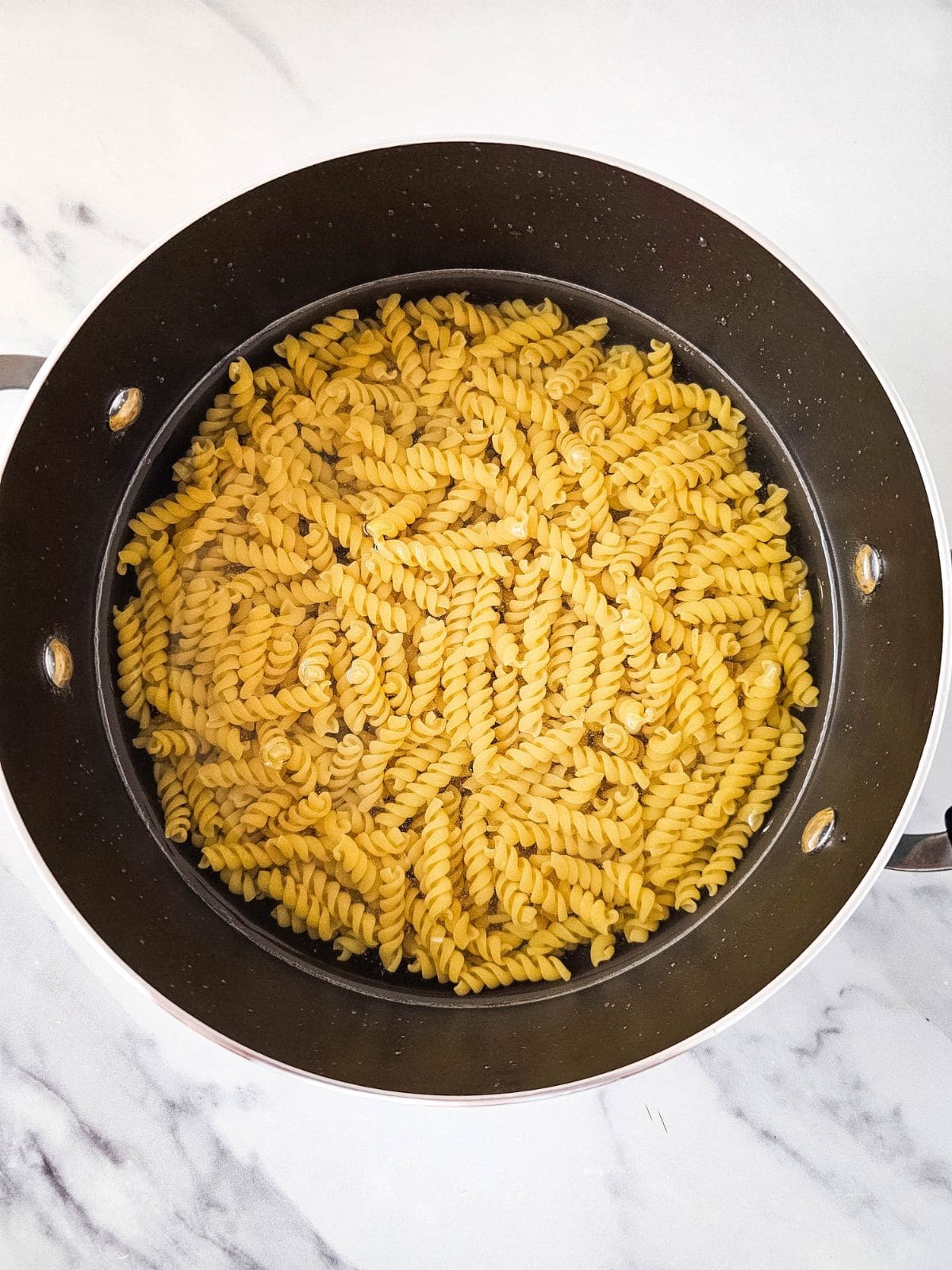 A large pot of water and spiral pasta.