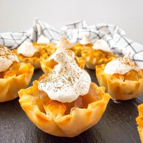 Peaches and cream pie bites are topped with whipped topping and cinnamon.