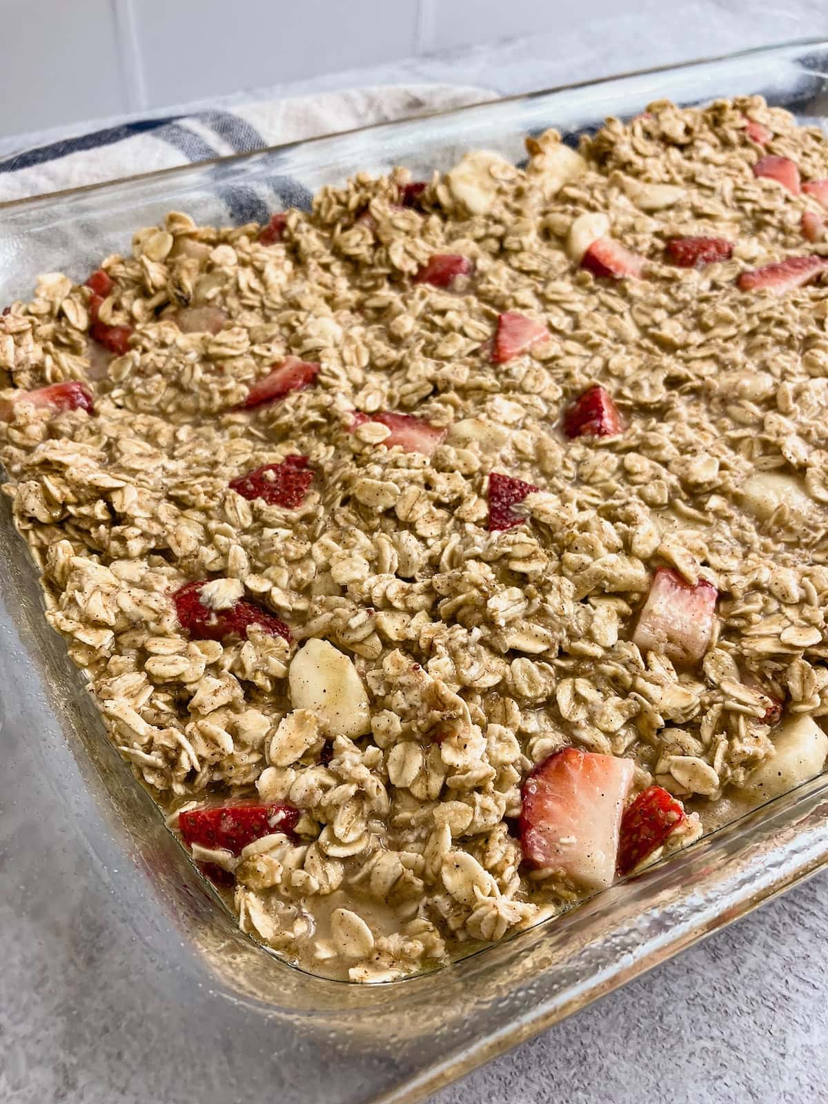 Raw strawberry banana oatmeal batter poured into a baking dish.