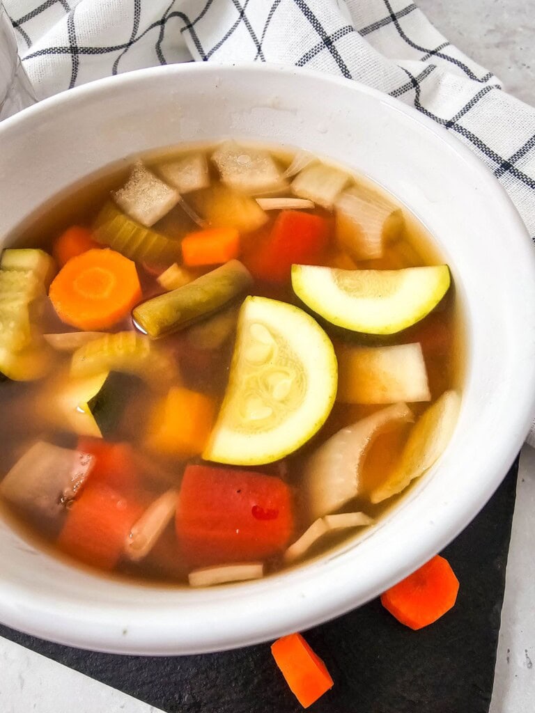 A bowl of homemade vegetable soup made with summer vegetables.