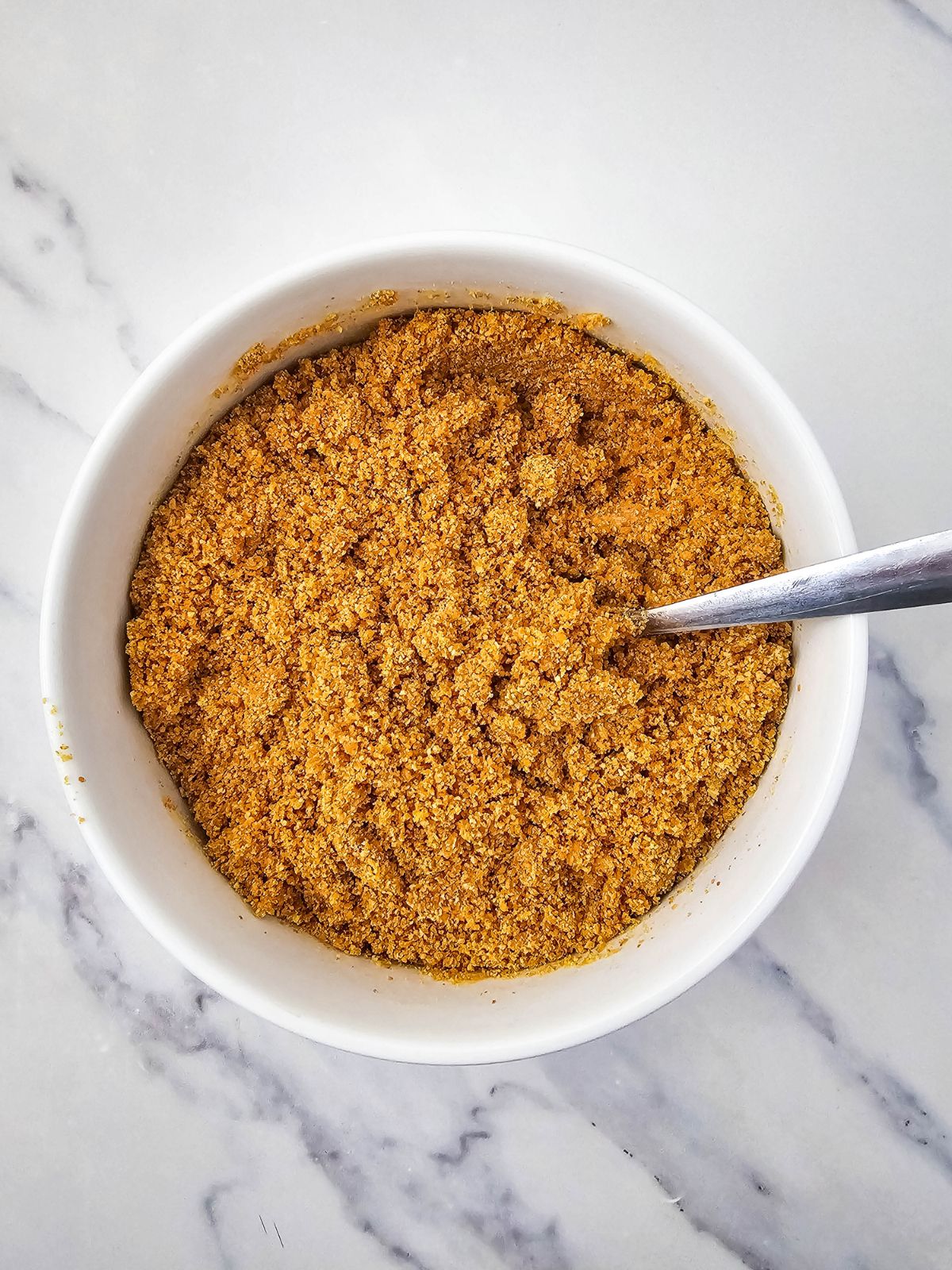Graham crackers mixed with butter and ready to press into the pan.