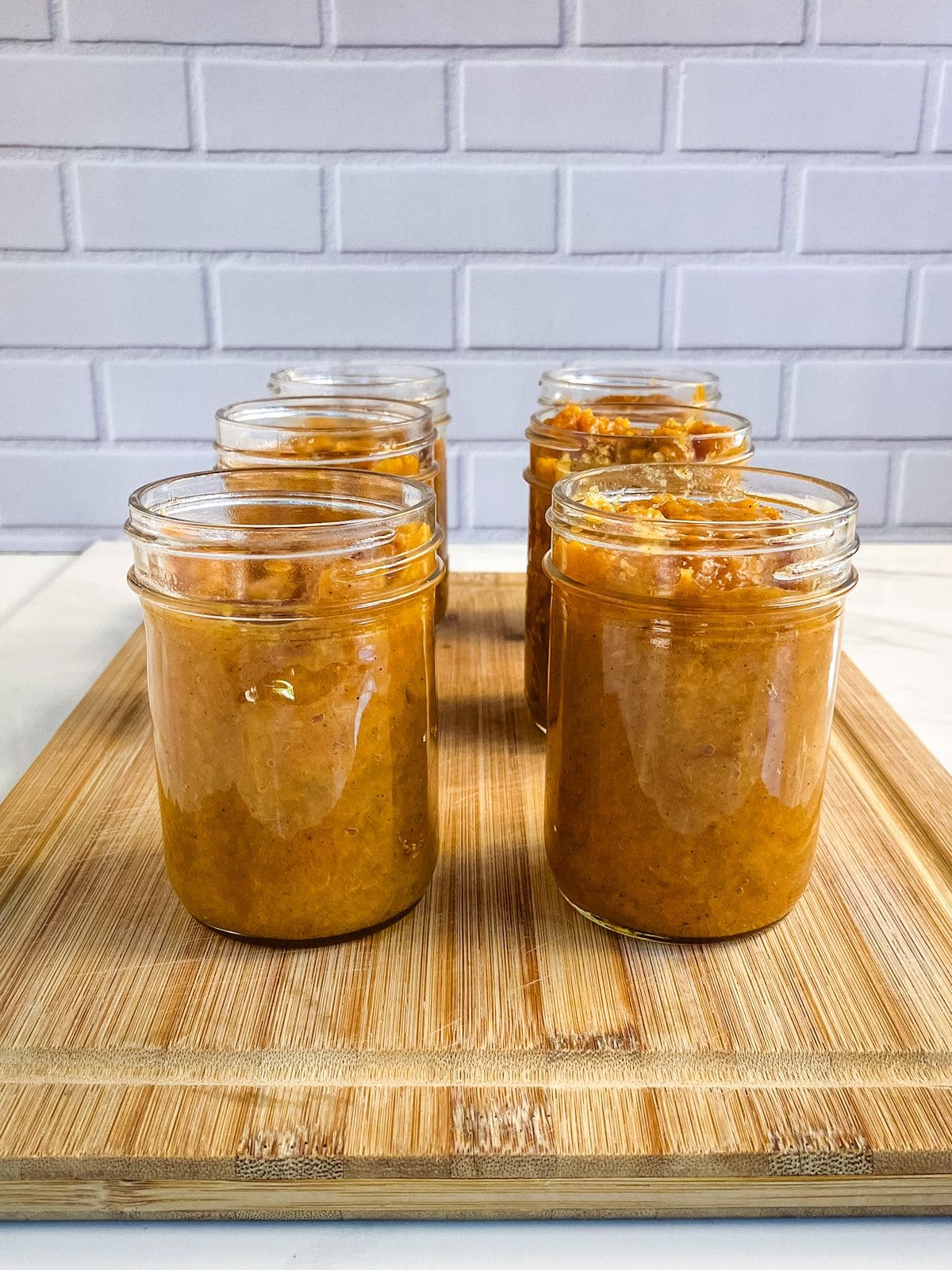 Peach butter ladled into half-pint jars.