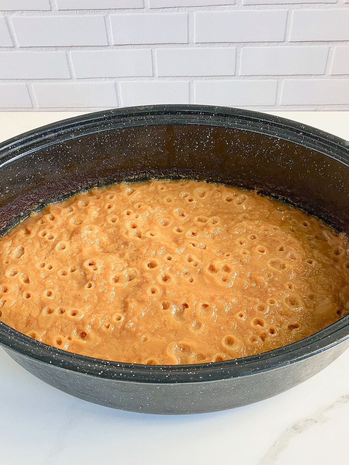 Half-cooked peach butter in a roaster.