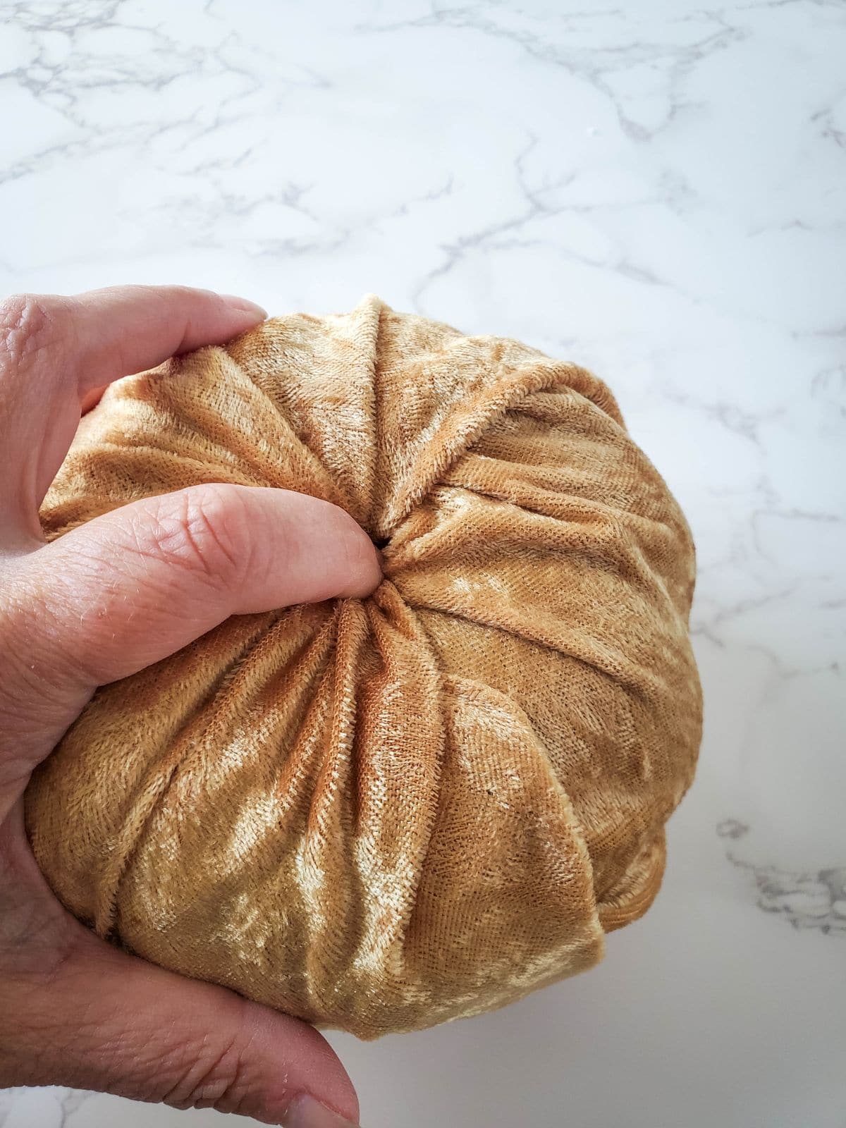 Pressing the velvet into the pumpkin stem hole tightly.
