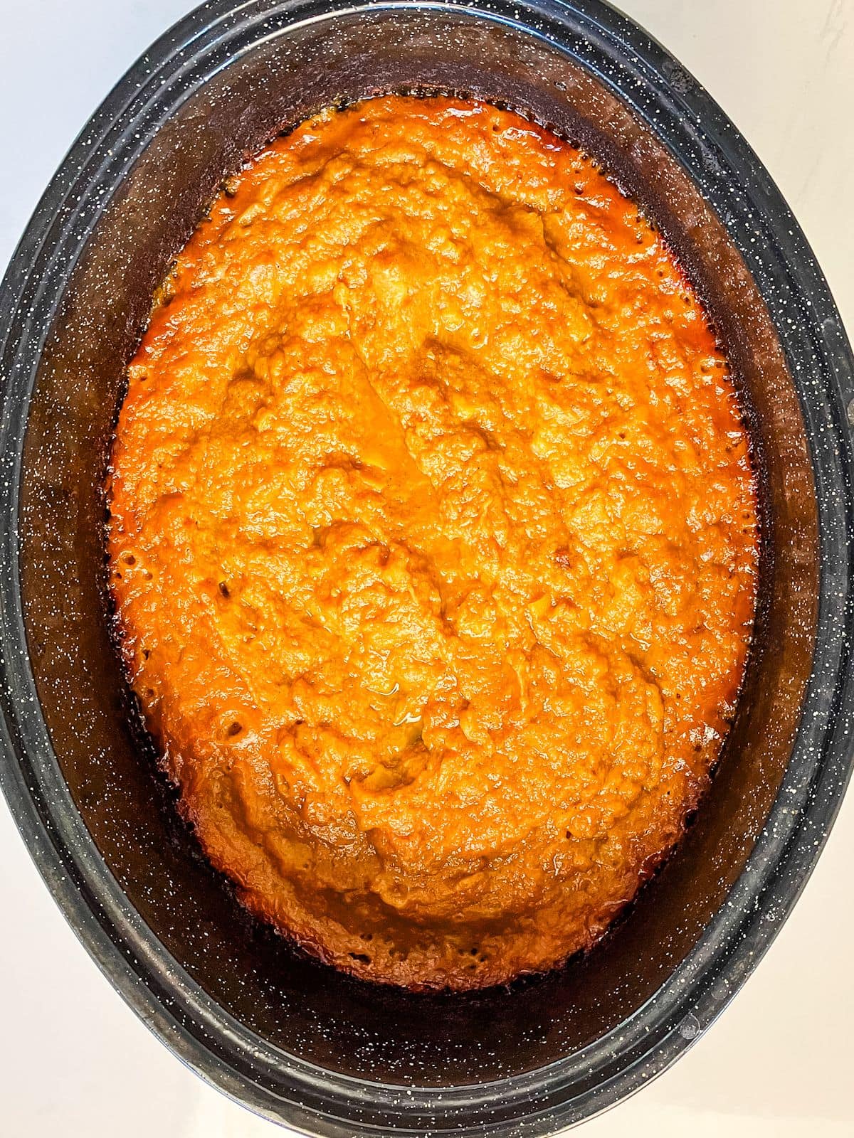 A roasting pan of cooked peach butter.