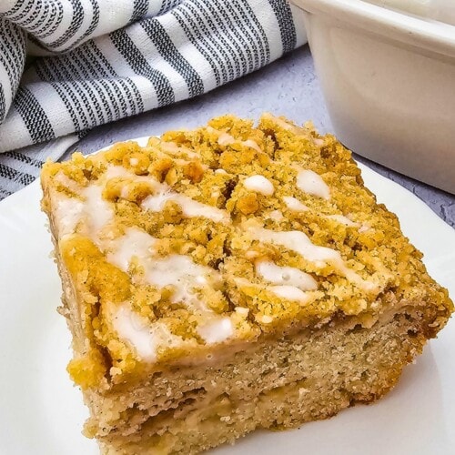 Easy apple crumb cake sliced on a white plate.