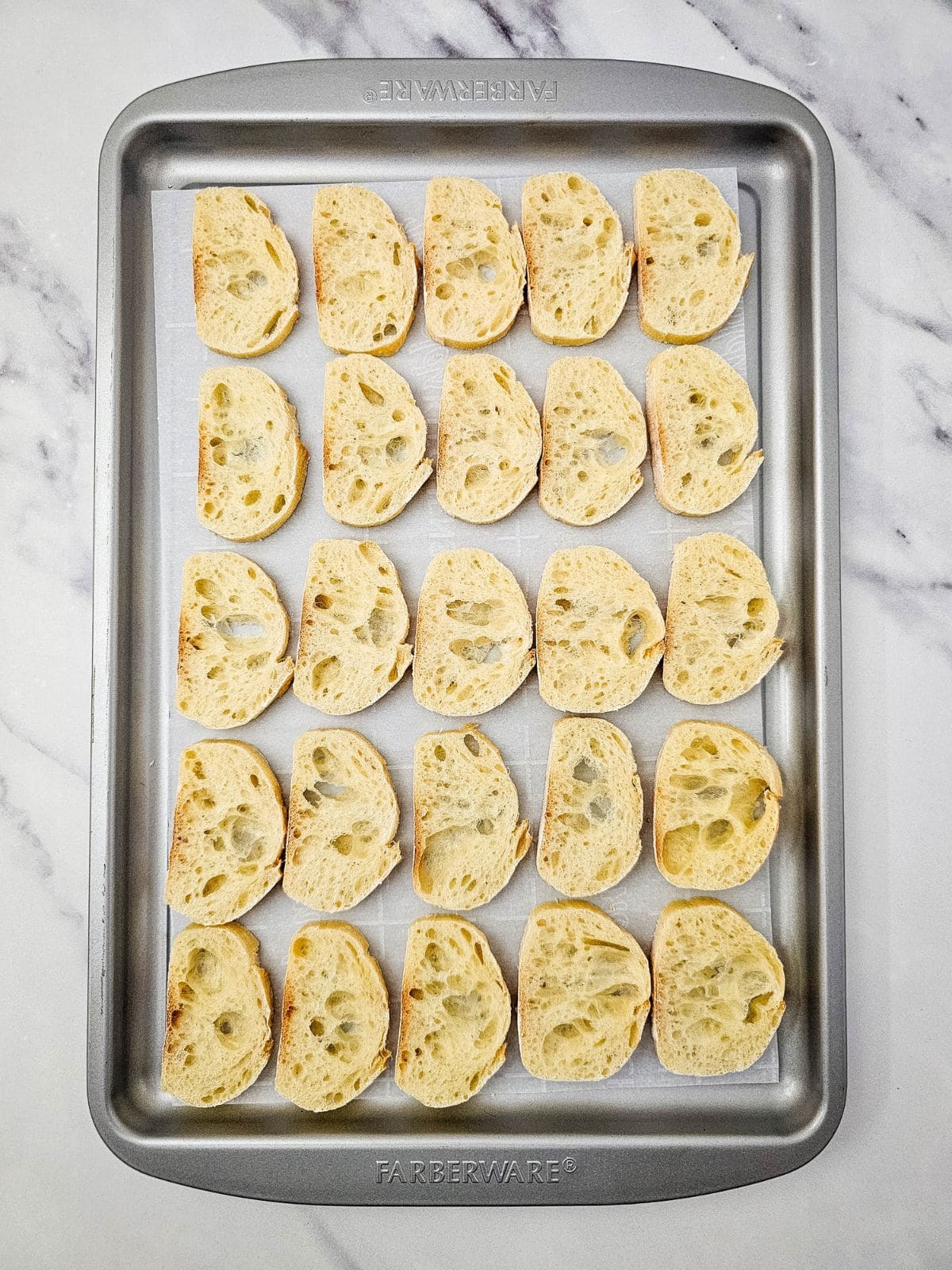 Baguette slices on a baking sheet.
