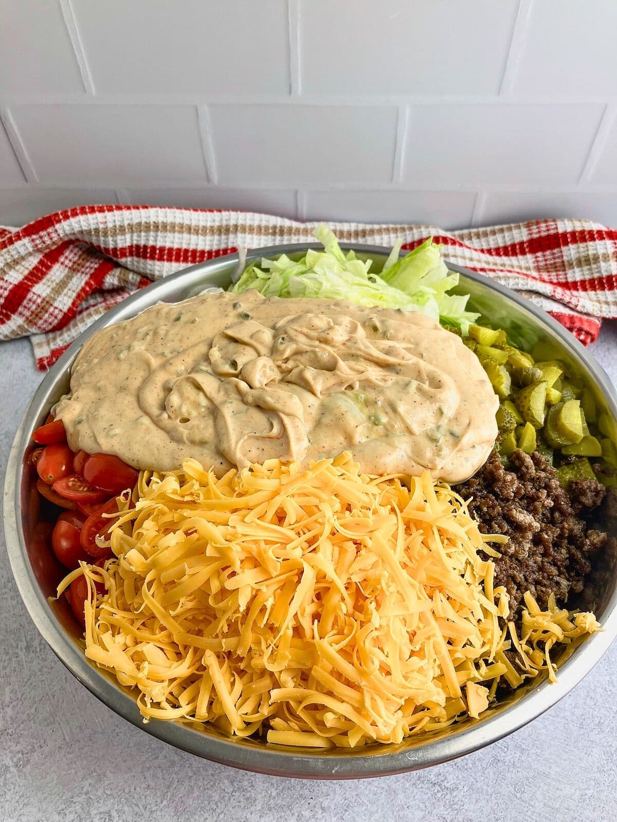 Homemade burger sauce poured over the pasta salad ingredients.