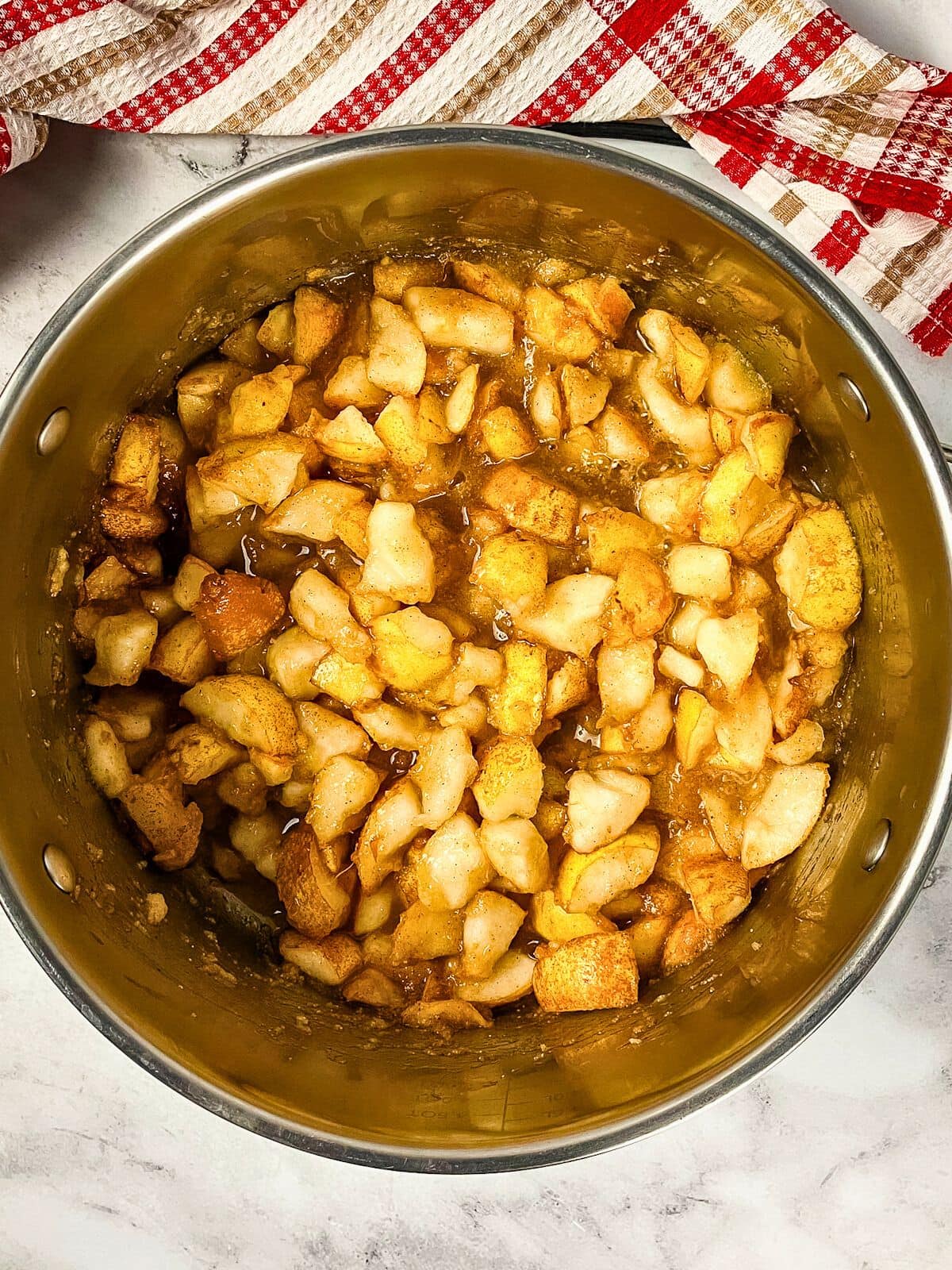 Diced pears and spices cooking in a large pot.