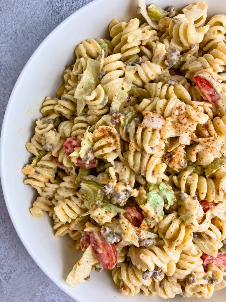 A white serving bowl of cheeseburger pasta salad.